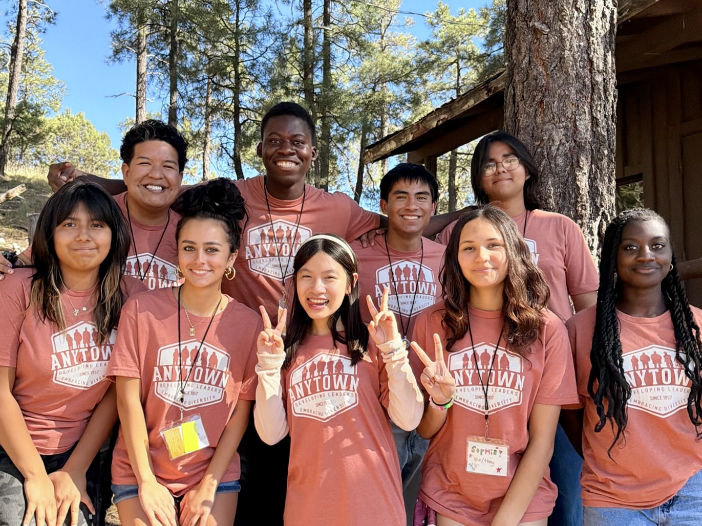 Anytown delegates in coral camp shirts smiling together at camp