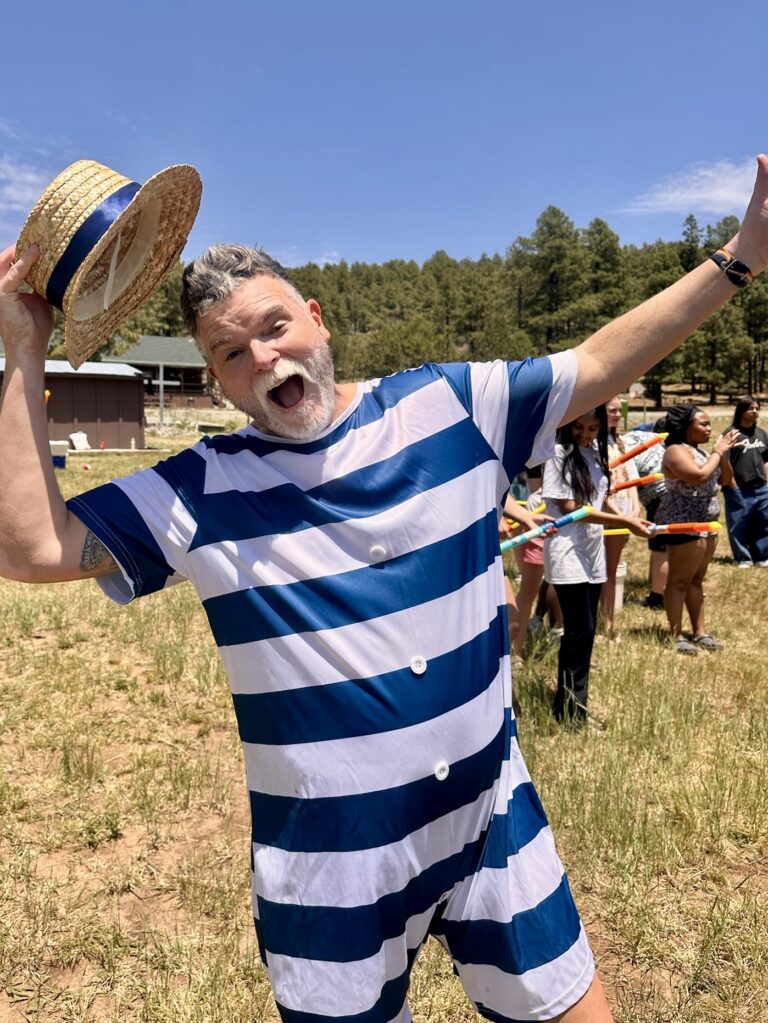 Anytown staff member in a striped costume cheering