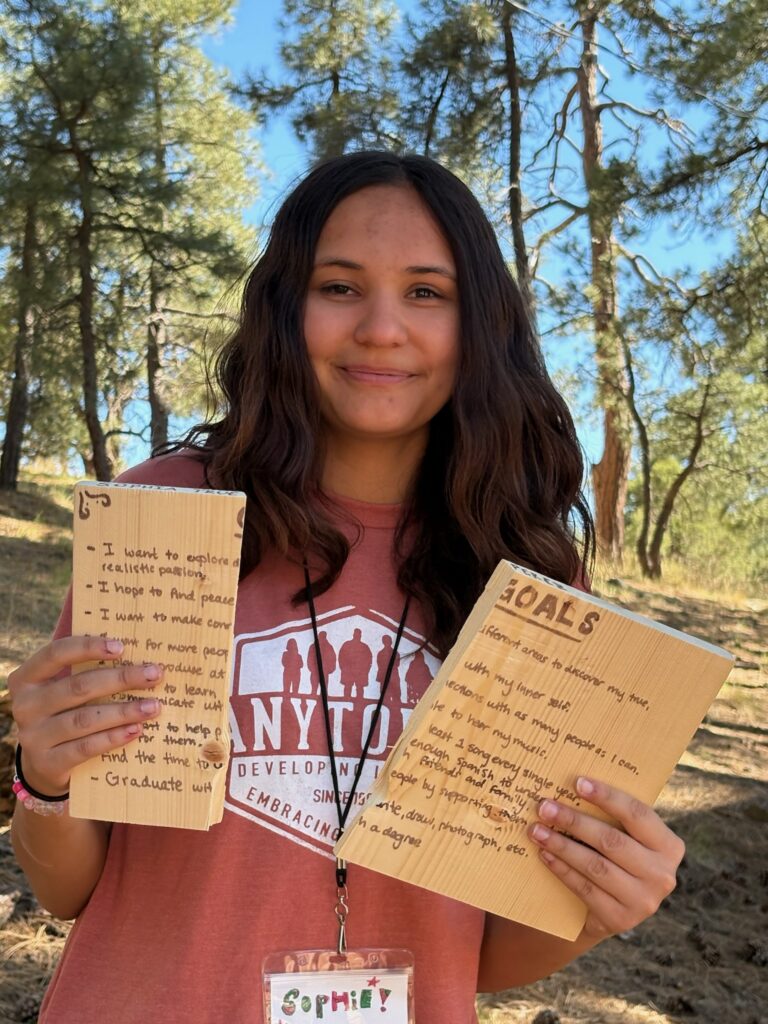 Sophia, Anytown delegate, holding her goal boards at camp