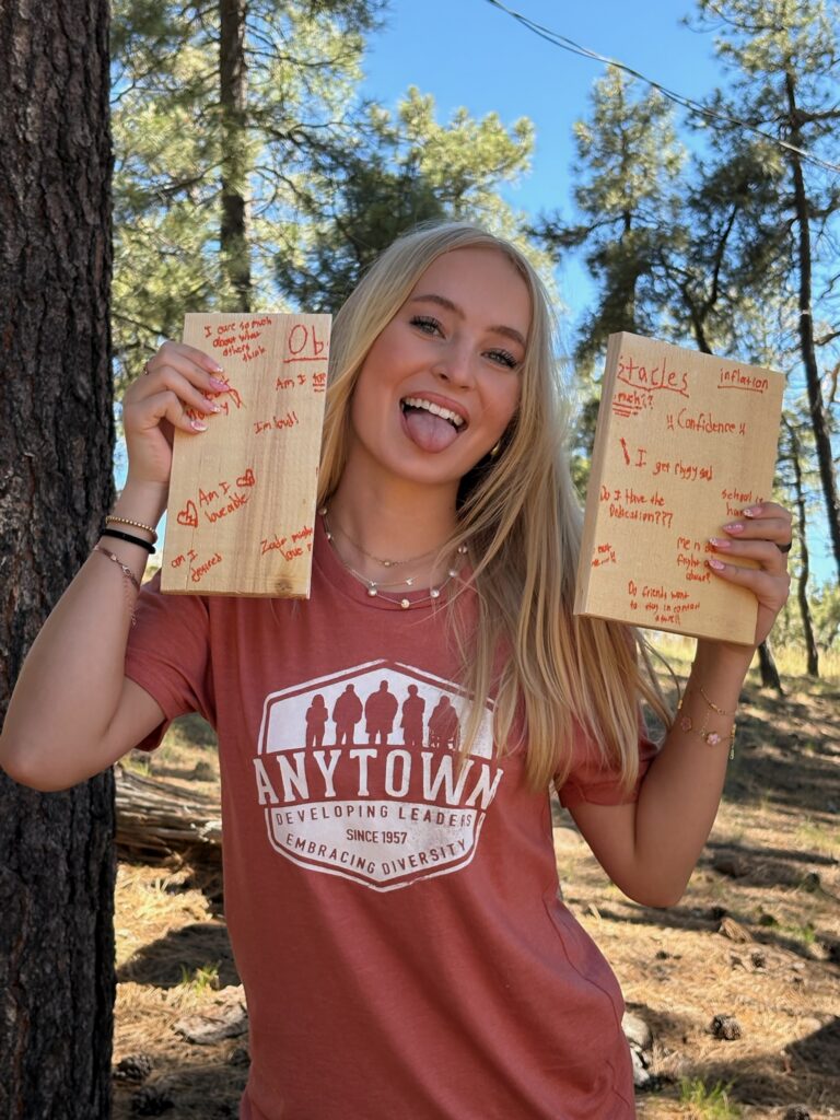 Anytown alum laughing and holding goal boards